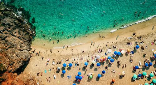 Strand met parasols aan azuurblauwe zee