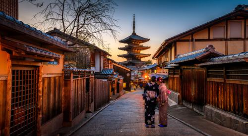 Traditioneel geklede Japanners in straat met Japanse huizen